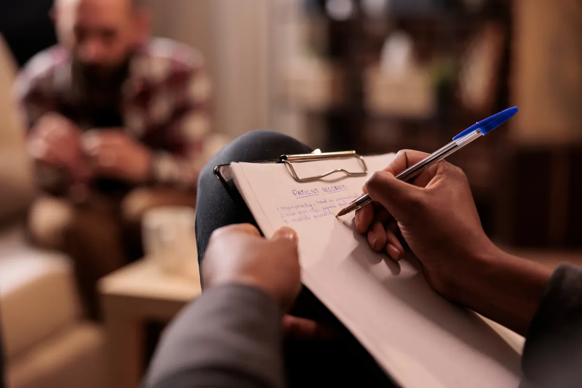 Therapist taking session notes during a counseling session